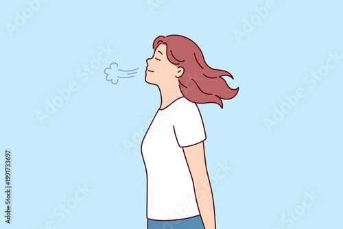 Woman exhaling breath on a cold day or breathing deeply to relax. Concept of fresh air, meditation, mindfulness, and healthy lung function.