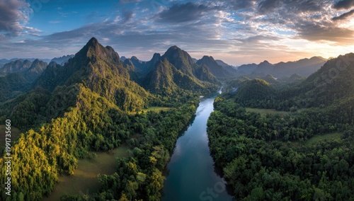 Serene river winds through lush green mountains at sunset, dramatic clouds