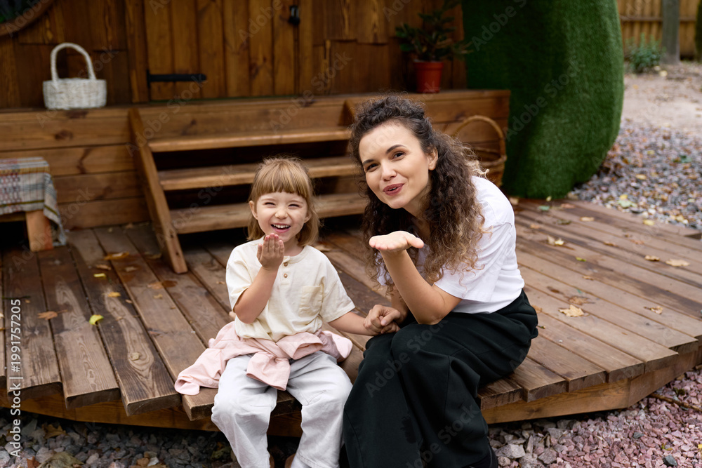 Obraz premium Joyful moments shared between a young mother and her daughter at an amusement park
