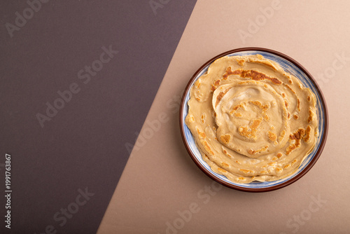 Stack of Plain Fried pancakes on gray and beige pastel paper. top view, flat lay, copy space