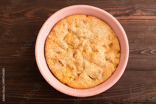Apple Charlotte cake in baking dish on brown wooden, top view, flat lay, close up