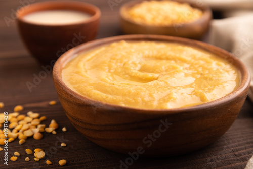 Pea cream soup, Puree, porridge in wooden bowl on wooden, side view, close up, selective focus