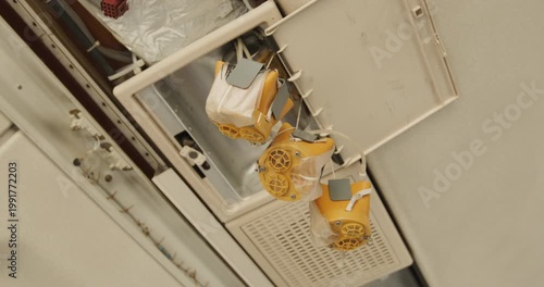 Close-up of yellow emergency oxygen masks deployed and hanging from an aircraft ceiling