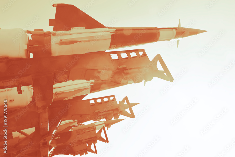 Naklejka premium Anti-aircraft cruise missiles on a launcher on blue sky background missiles are aimed to sky at day Nuclear bomb, chemical weapons, missile defense system of salvo fire Metallic missile rocket