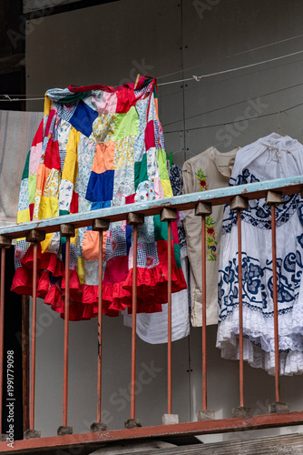 Vibrant patchwork pollera and embroidered dresses hanging on a clothesline in Casco viejo, Panama city, drying outdoors - stock photo