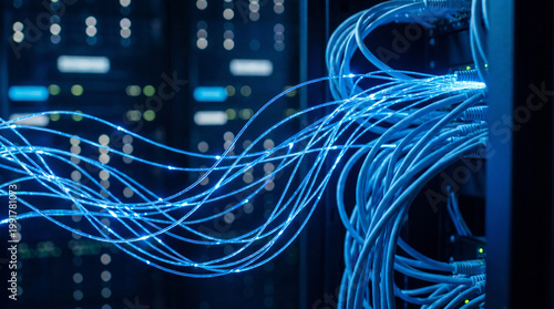 Photos Close-up of glowing blue fiber optic cables and network wires in a modern server room for high-speed data transfer