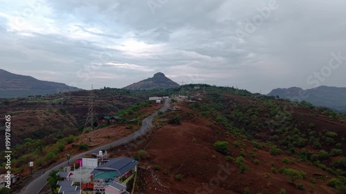 Moving drone shot of a road going up a mountain with dramatic clouds in the background 4K30 fps.