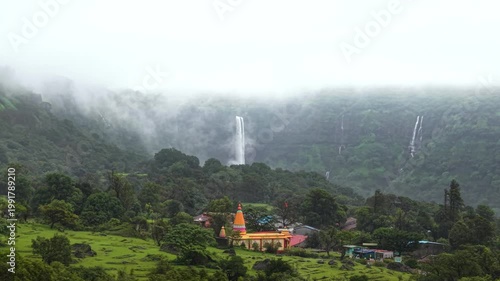 Moving Drone shot of a temple with a waterfall in the background shot in the mountians of India. 4K60fps