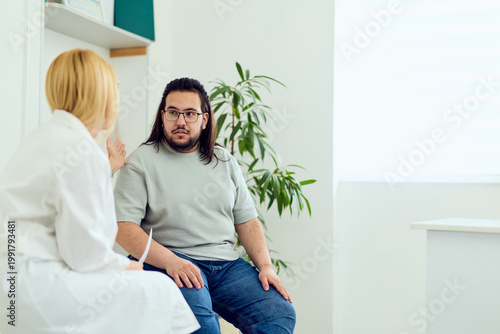Doctor Consultation With Male Patient In Medical Clinic Discussing Health and Weight Management