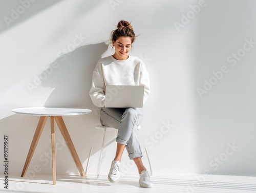 young woman working on laptop in bright modern room