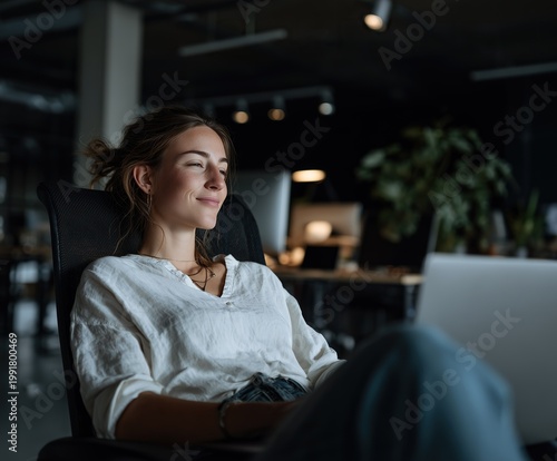 business woman celebrating success on laptop in modern office at night