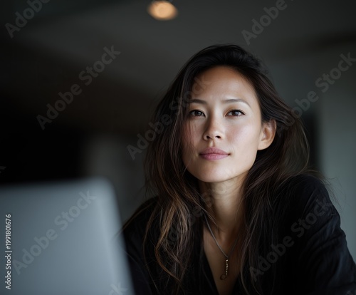 asian business woman working on laptop in modern office portrait