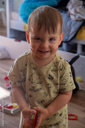 Smiling toddler playing with toys in a cozy home playroom Portrait