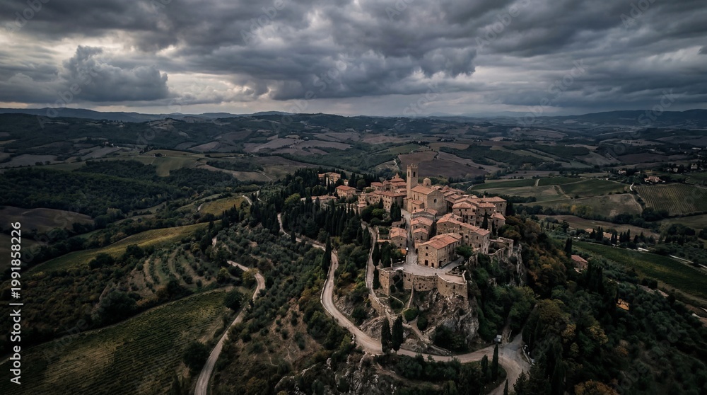 Obraz premium Aerial View of a Medieval Tuscan Village Perched on a Hilltop Under Dramatic Clouds.