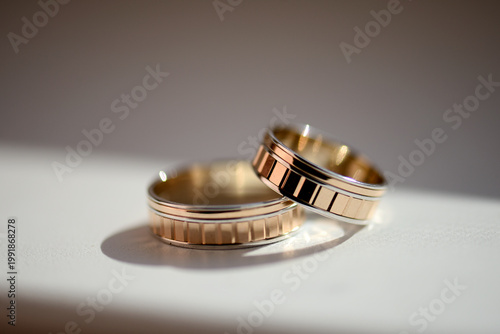 Tableau sur toile Gold wedding rings of the bride and groom on a white background with natural light