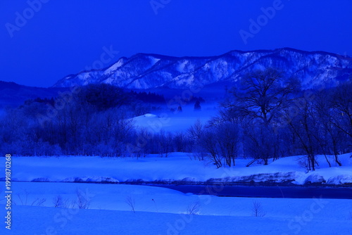 朝陽に染まる樹氷と川霧