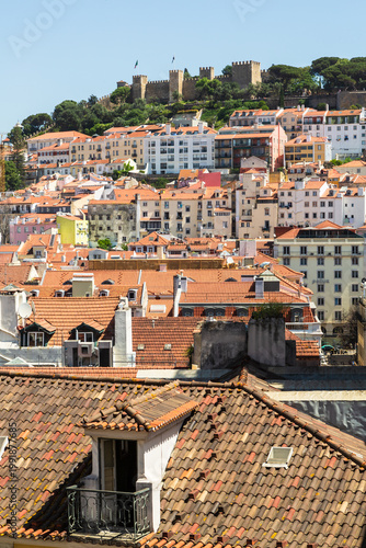 Lisbon, Portugal - 15 April 2024: View over the city center of Lisbon with historic fortress Castelo de Sao Jorge on a hill and houses with colorful facades underneath