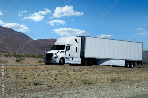 truck driving on highway through nature and mountains. Commercial vehicle transport for logistics and shipping.