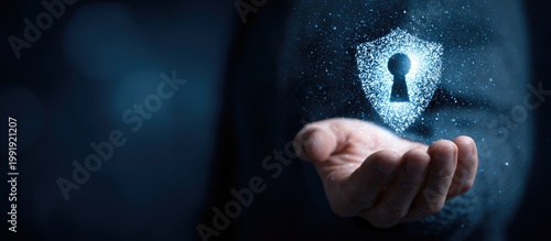 A hand holding a glowing digital shield with a keyhole. Dark background, concept of protection