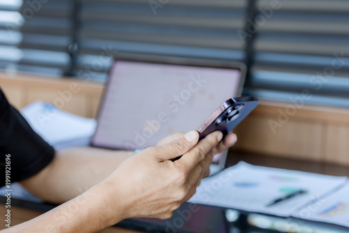 Smiling businesswoman working on laptop in café, enjoying hot drink, analyzing charts, planning projects, and staying connected in a modern professional lifestyle.

