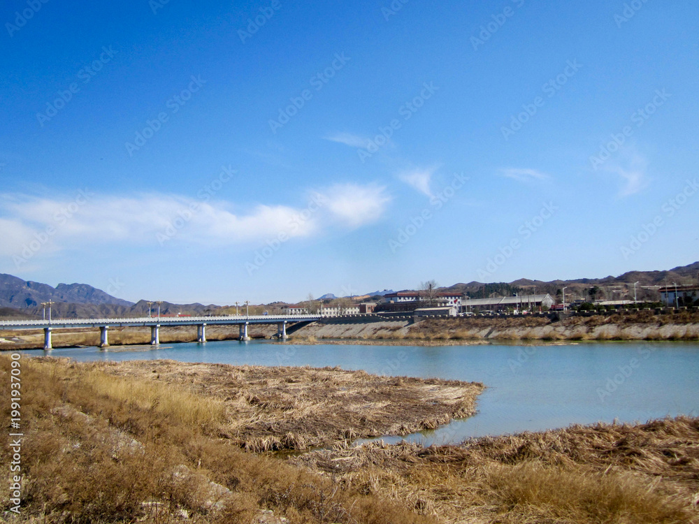 Fototapeta premium Scenic river view with bridge and clear blue sky