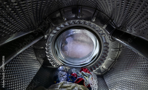 Inside View of Washing Machine Drum with Wet Laundry and Soap Suds