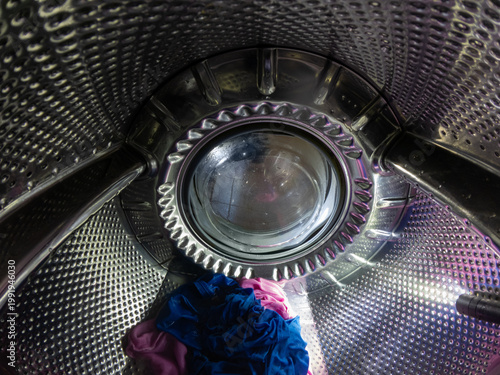 Inside View of Washing Machine Drum with Blue and Pink Laundry