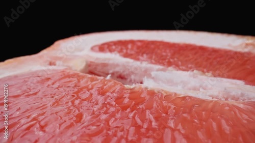 Half of juicy grapefruit. Dolly slider shot with macro lens. Organic healthy food concept. Tasty citrus fruit. Close-up in 4K, UHD