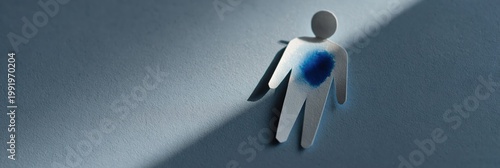 Paper cutout person with blue chest stain in diagonal beam of light