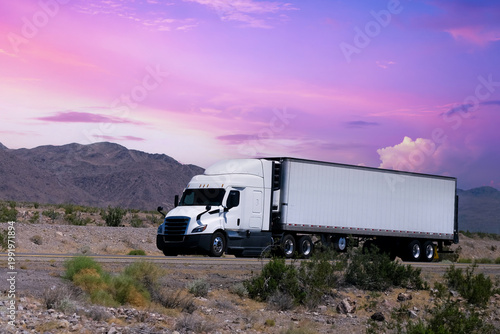 Truck driving on highway through nature and mountains. Commercial vehicle transport for logistics and shipping.