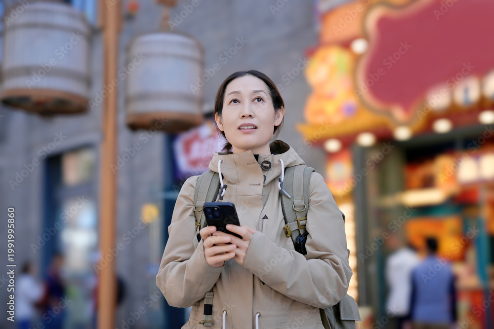 Fototapeta premium Woman with Backpack Using Smartphone in Urban Area