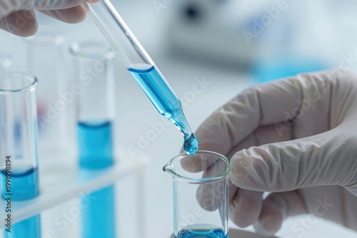 Lab worker conducts test with blue liquid in glassware during a research project