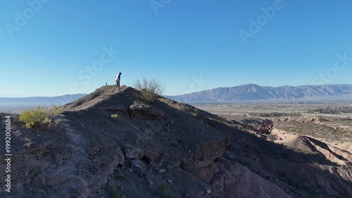 Aerial drone view of dry mountain landscape in San Juan Argentina under clear blue sky