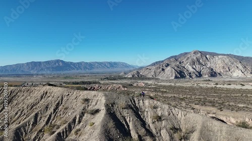 Aerial drone view of dry mountain landscape in San Juan Argentina under clear blue sky