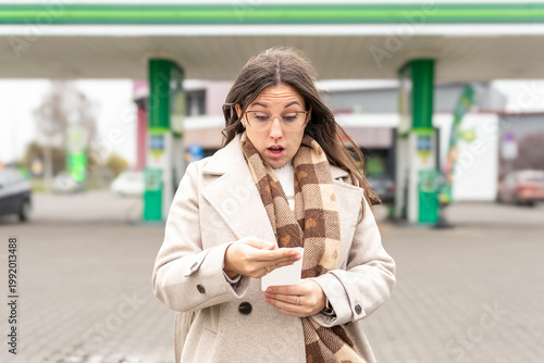 Fuel inflation concept woman shocked by gas receipt