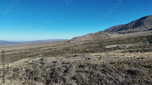 Aerial drone view of dry mountain landscape in San Juan Argentina under clear blue sky
