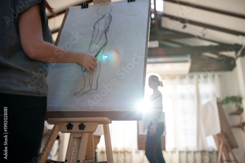 Artistic sketching in sunlit studio.
