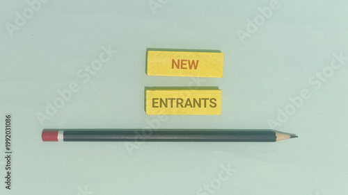 Foto A minimalist visual with 'NEW ENTRANTS' text blocks, a pencil, and an eraser, me