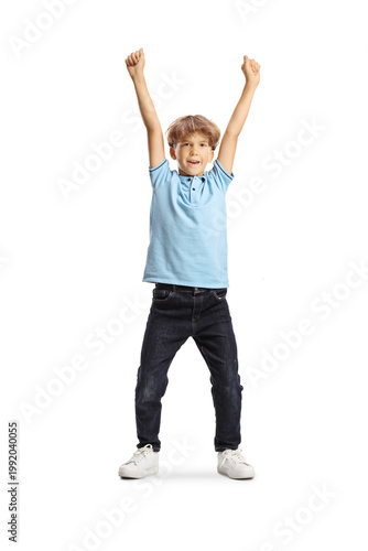 Fotografía Joyful young boy celebrating with arms raised in the air