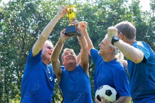 Fotografie Senior team celebrating victory outdoors