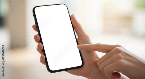 Hand holding a smartphone with blank screen, close-up, with copy space