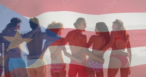 Standing eight adults linking arms on sandy shore, wearing swimwear under Puerto Rican flag overlay