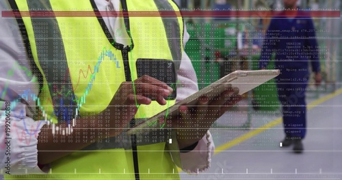 Inspecting worker wearing hi-vis vest and necktie, tapping tablet with data overlay in warehouse
