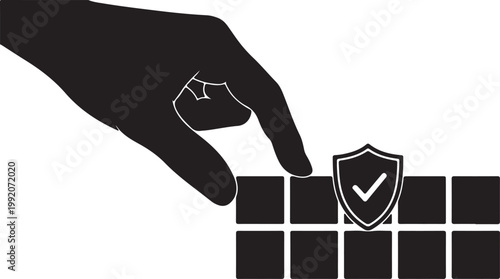 Hand placing a shield icon with a checkmark onto a grid, symbolizing security, protection, and verification in a digital or physical context