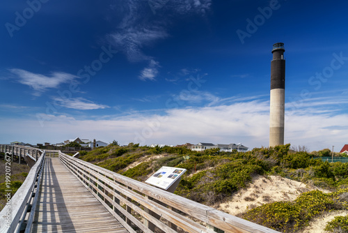 view of the baordwalk and public beach access at Caswell Beach with thev Oak Island Lighthouse behind