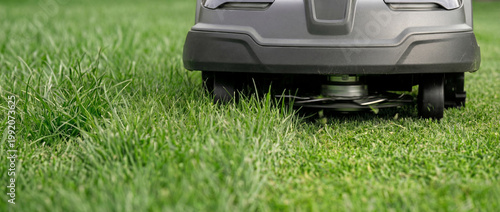 Close up of lawn mower blades cutting grass. Mowing the lawn with an automatic mower