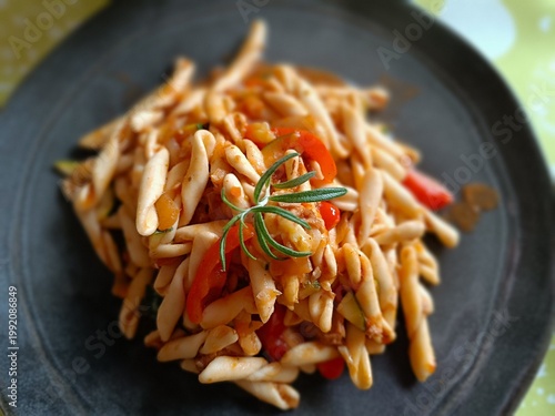Fotografie Fresh made pasta with vegetable and tuna fish and rosemary herb on black plate f