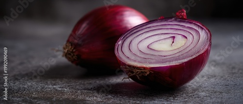The Red Onion Halved Showing Concentric Rings On Rustic Stone Surface