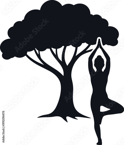 Woman performing tree yoga pose next to large tree silhouette.