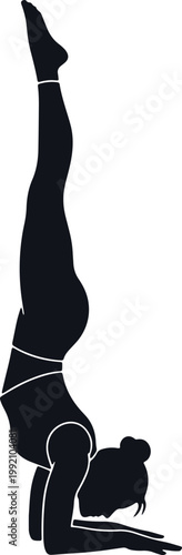 Woman performing difficult yoga handstand silhouette.